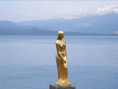 たつ子の像と田沢湖の青い湖水写真