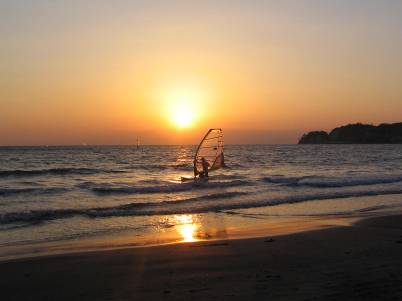 材木座海岸の夕日とウインドサーフィン写真